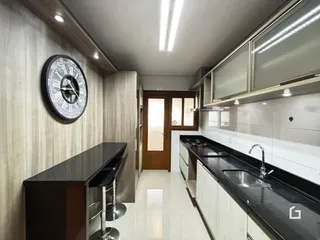 Vista interna de uma cozinha com armários e piso claro.