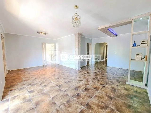Foto de um ambiente interno com piso de ladrilhos marrons e paredes brancas.