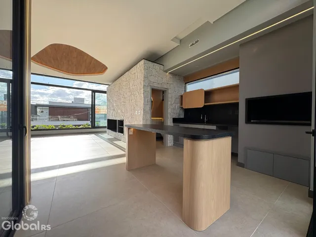 Interior de uma sala de estar com grande janela e cozinha moderna.