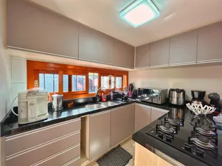 Foto de uma cozinha com armários e bancadas escuras.