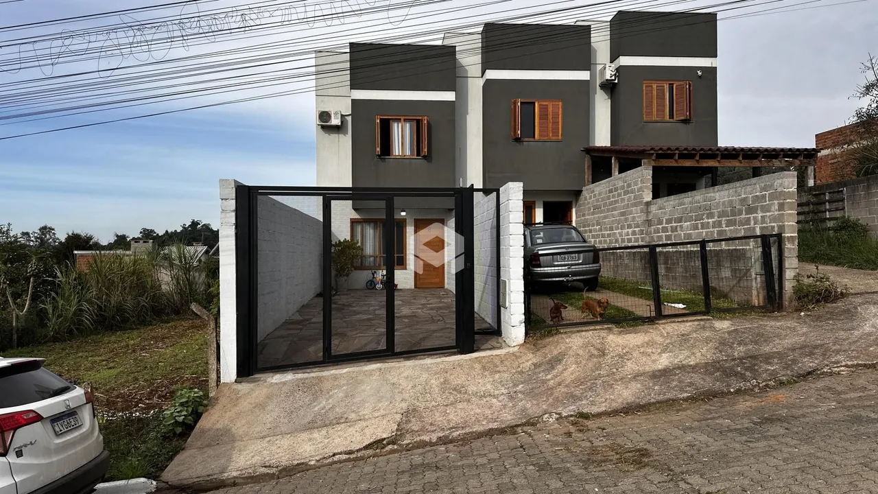 Fachada de uma residência em Lajeado, Brasil, com portão de ferro.