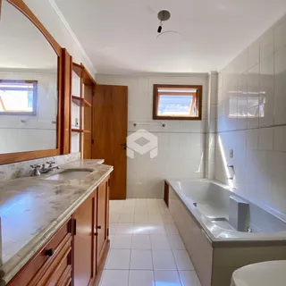 Foto de um banheiro com banheira e bancada de mármore.