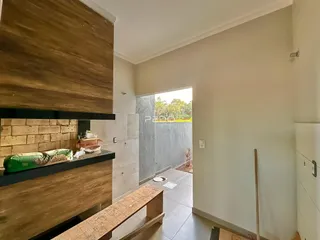 Interior de uma sala com piso de cerâmica e parede de madeira em Lajeado, Brasil.