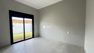 Interior de uma sala com porta de vidro voltada para o exterior.