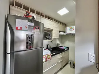 Uma cozinha moderna com armários brancos e eletrodomésticos de aço inoxidável.