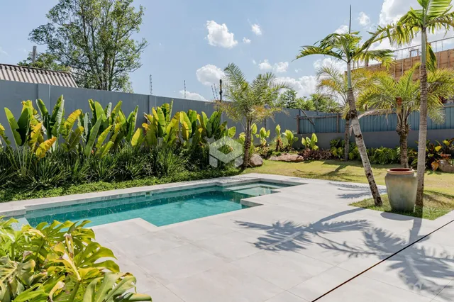 Foto de uma piscina e jardim em uma propriedade no Brasil.