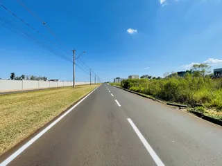 Vista de uma estrada longa com vegetação ao lado.