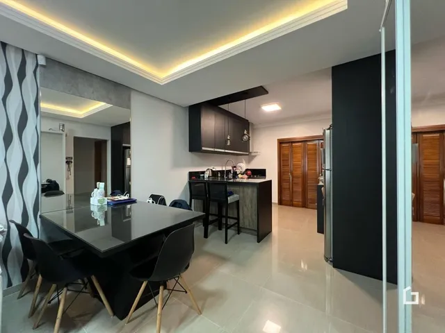 Imagem de uma sala de jantar e cozinha moderna com piso claro.