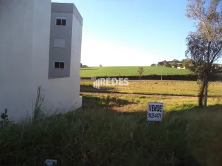 Fachada de uma residência branca em Lajeado, Brasil com um campo ao fundo.