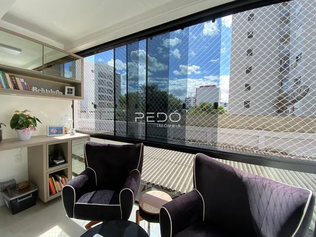 Sala de estar com grandes janelas que dão vista para o exterior.
