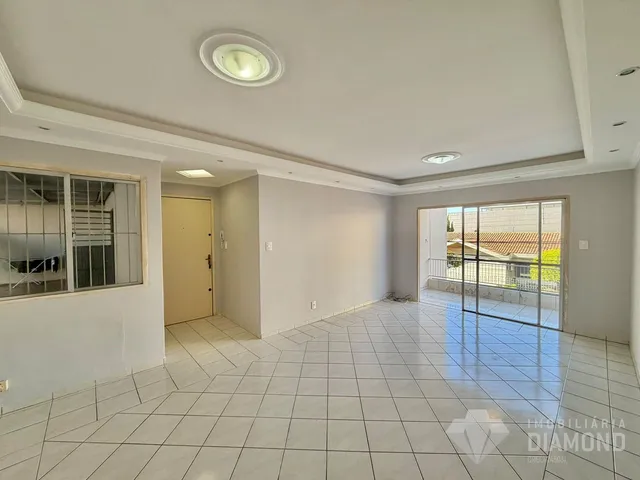 Ambiente interno de uma sala ampla com piso de cerâmica clara.