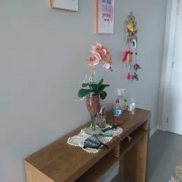 Parede cinza lisa com decoração floral na área comum.