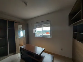 Quarto com armários embutidos e janela na sala de um imóvel em Lajeado.