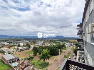 Vista aérea de uma área residencial em Lajeado, mostrando casas e vegetação.