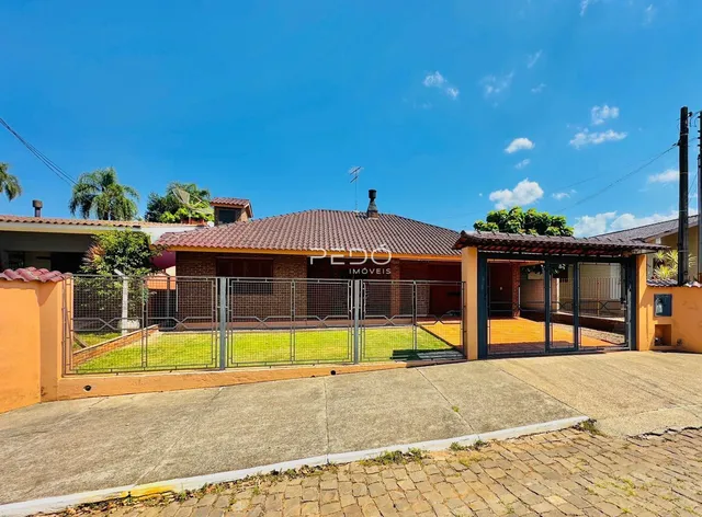 Fachada de uma residência em Lajeado, Brasil, com cerca e portão de ferro.