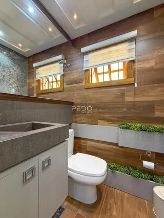 Foto de um banheiro moderno com bancada e vaso sanitário.