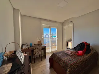 Quarto com vista para a paisagem externa e porta de vidro.