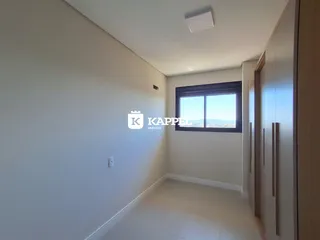 Foto de um corredor interno com paredes brancas e uma janela.