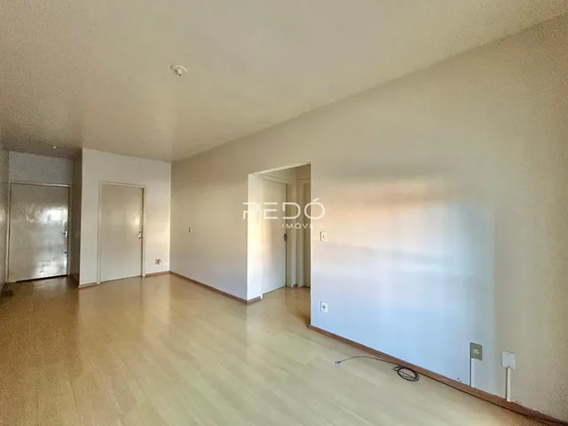 Vista interna de um corredor com piso de madeira clara e portas brancas.