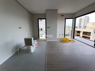 Interior de um ambiente moderno com piso de madeira clara e grandes janelas.