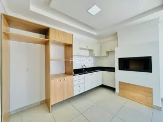 Foto de uma cozinha moderna com armários de madeira clara e piso de cerâmica.
