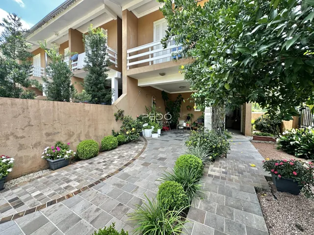 Fachada de um imóvel em Lajeado, Brasil, com jardim e calçadas pavimentadas.