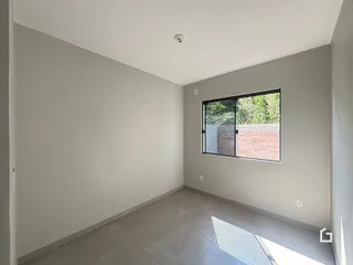 Ambiente interno de uma sala com piso de cerâmica e janela para o exterior.