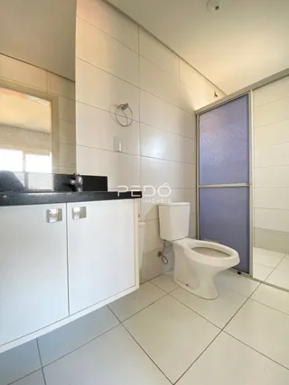 Foto de um banheiro interno com revestimento branco e louças sanitárias brancas.