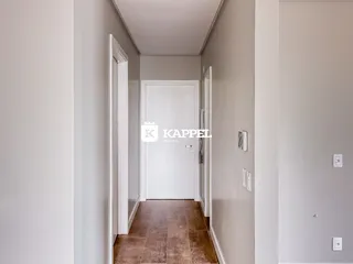 Corredor interno com paredes brancas e piso de cerâmica.