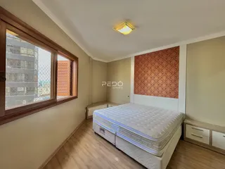 Quarto com janela e piso de madeira.