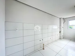Foto de um corredor interno com paredes brancas e piso claro.