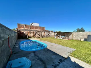 Vista externa de uma área com piscina e muro.