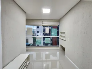 Corredor interno com piso claro e paredes brancas.