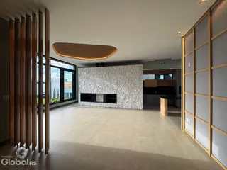 Espaço amplo com paredes de pedra e detalhes em madeira em uma residência.