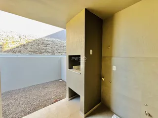Vista interna de uma área com paredes de concreto em reforma.