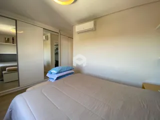 Quarto com cama e armários em um ambiente claro.