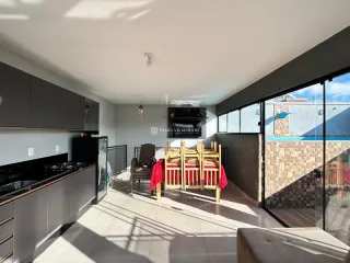 Sala de estar com piso de madeira e acesso a uma varanda.