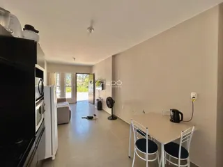Ambiente interno de uma sala de jantar com mesa e espaço aberto.