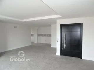 Interior de uma sala ampla com paredes brancas e piso claro.