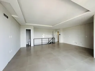Ambiente interno amplo com piso de cerâmica e paredes brancas.