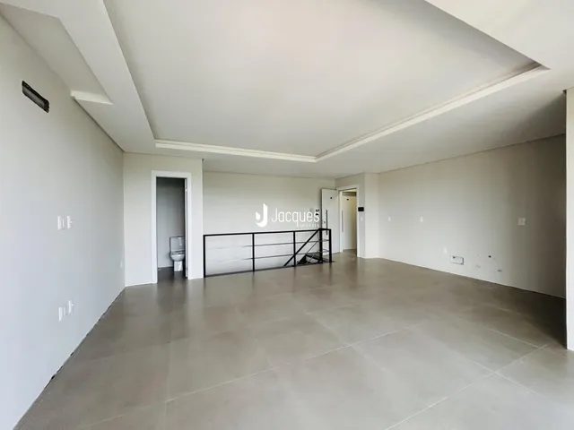 Ambiente interno amplo com piso de cerâmica e paredes brancas.