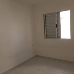 Foto de um ambiente interno com paredes brancas e piso de cerâmica.