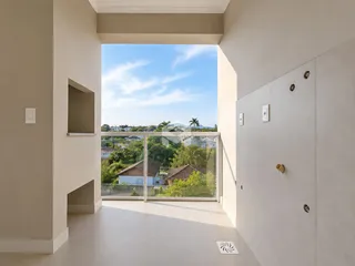 Vista de um corredor interno com acesso a uma varanda.