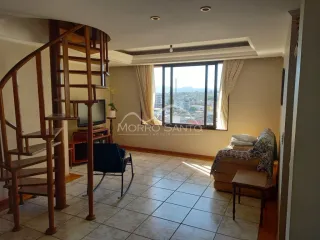 Sala de estar com escada de madeira e vista da janela.