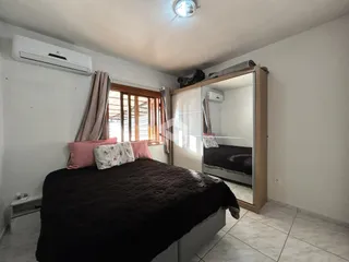 Quarto com cama e janela em um imóvel no Brasil.