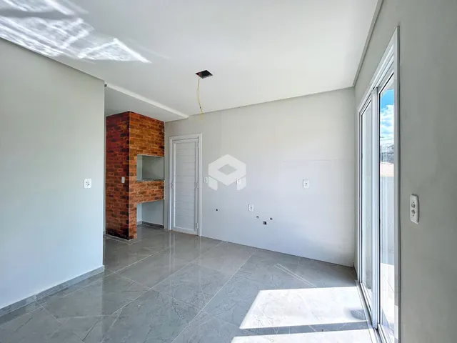 Vista de um corredor interno com piso de cerâmica e parede branca.