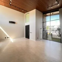Ambiente interno amplo com teto de madeira e piso claro.