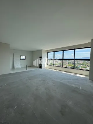 Espaço interno com grande janela de vista para a paisagem.