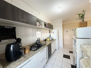 Esta é uma foto de uma cozinha com armários brancos e bancada de granito.