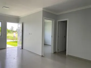 Um corredor interno com paredes brancas e piso claro é visível na propriedade.